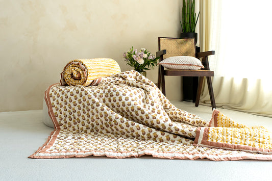 Queen-sized Indian block printed reversible quilt featuring a marigold floral pattern in mustard and terracotta pink hues, offering versatility and elegance to your bedding ensemble.