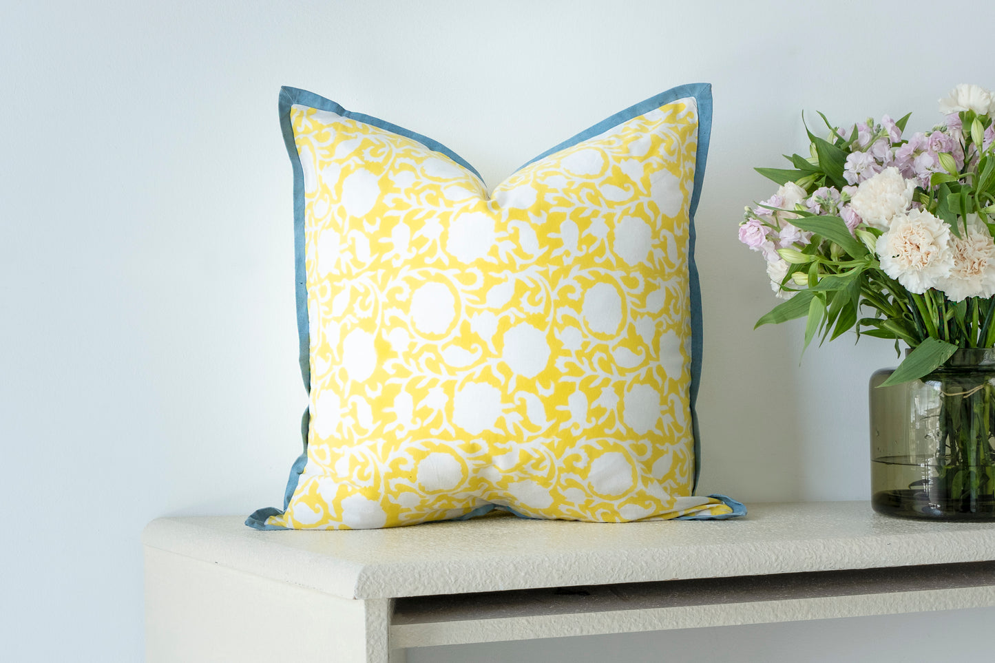 Handmade cotton cushion/pillow cover featuring a floral pattern, block-printed for a unique artisanal touch. Available in bright yellow and pink, adding vibrancy and elegance to your home decor.